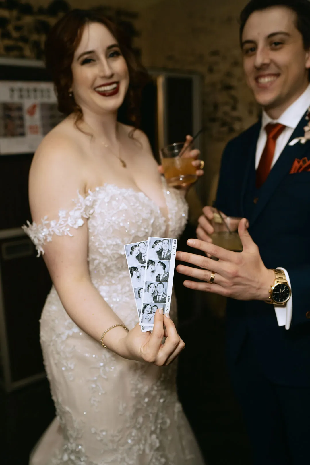 Couple holding drinks together at their reception