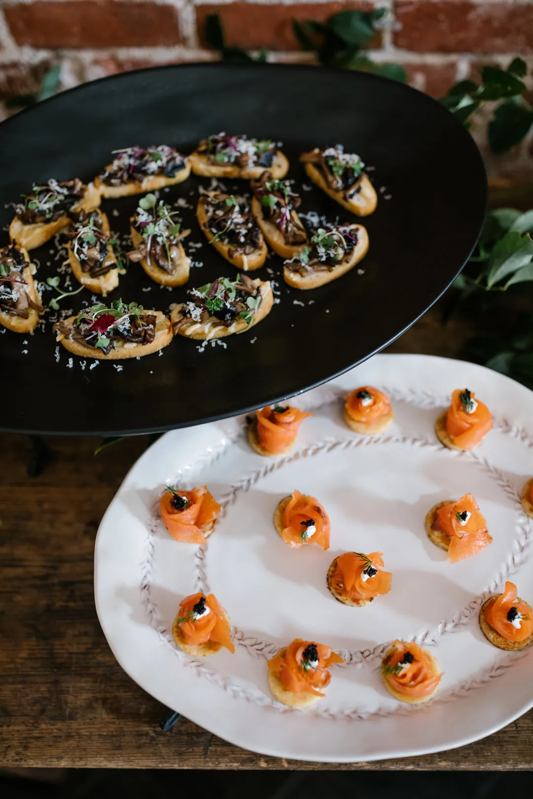 Small appetizers on black and white serving platters