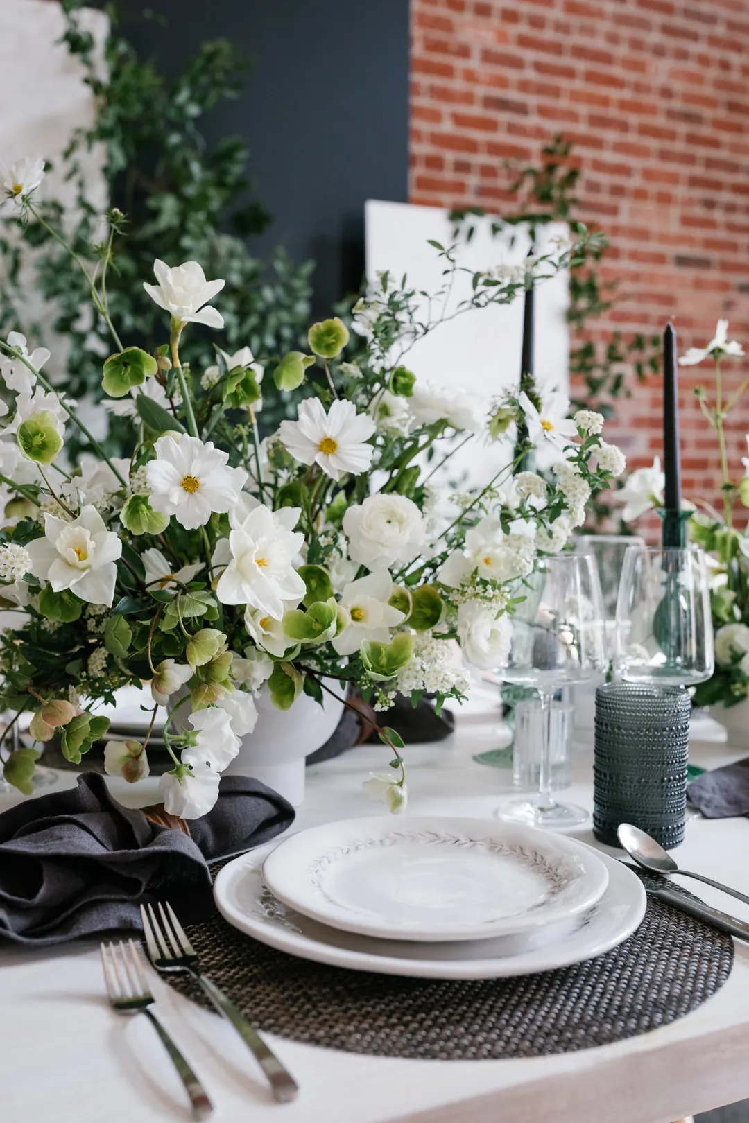 White flowers and candles beside a dinner place setting