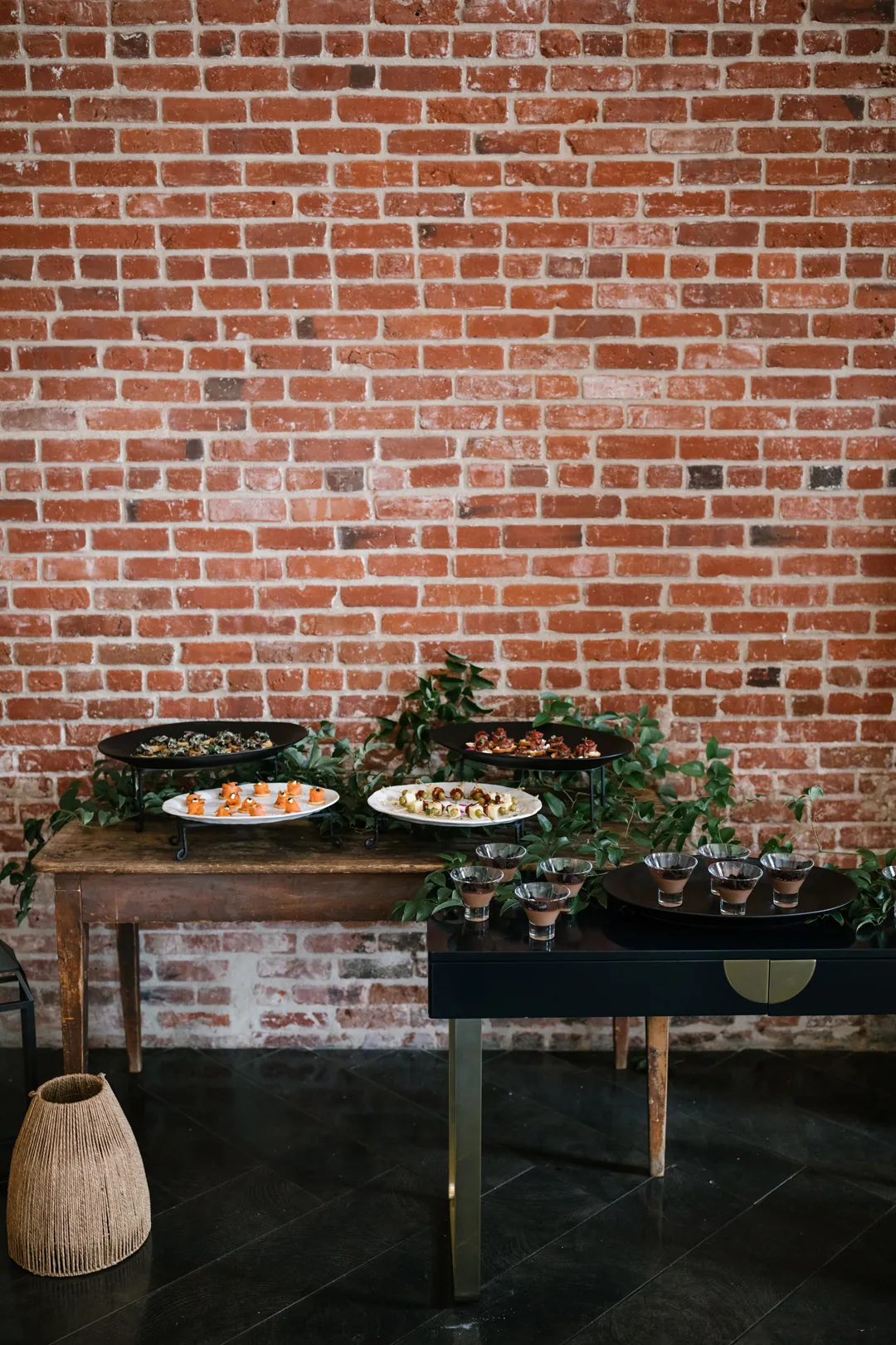 Two plated dishes on a small table beside a brick wall