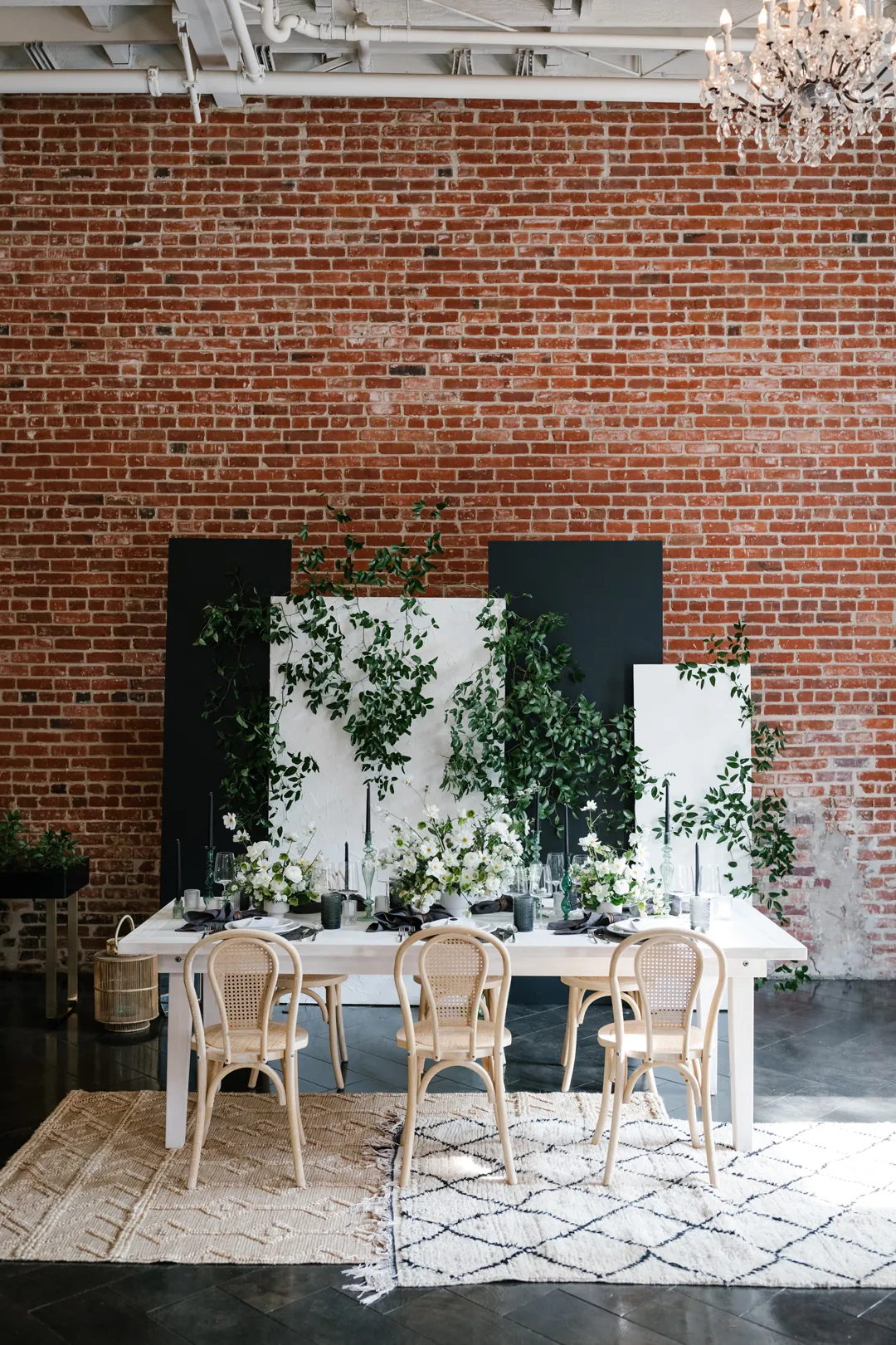 Dining table set before a white and green floral backdrop