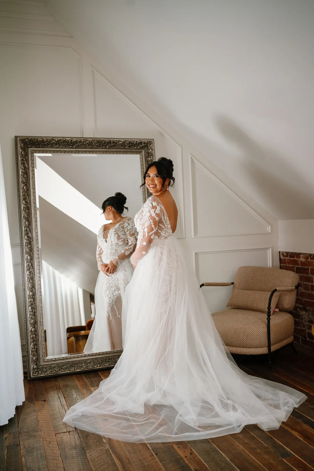 Bride looking at her reflection in a tall mirror