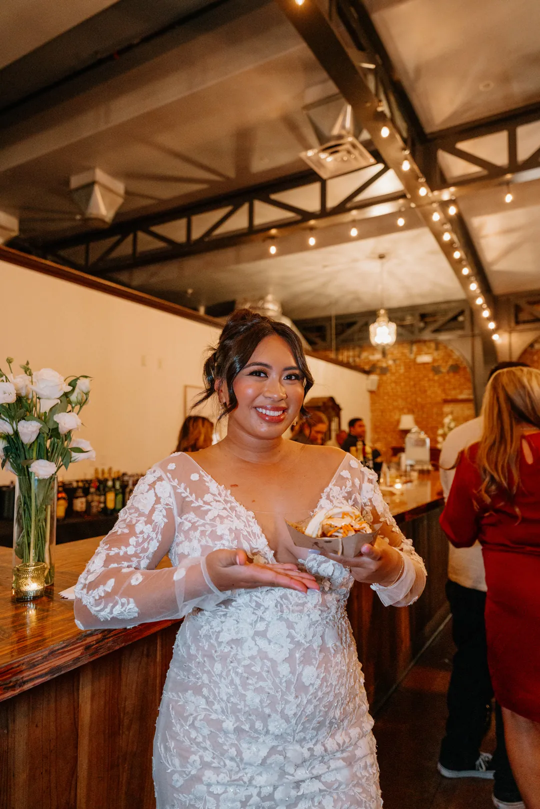 Guest holding a drink beside a wooden bar