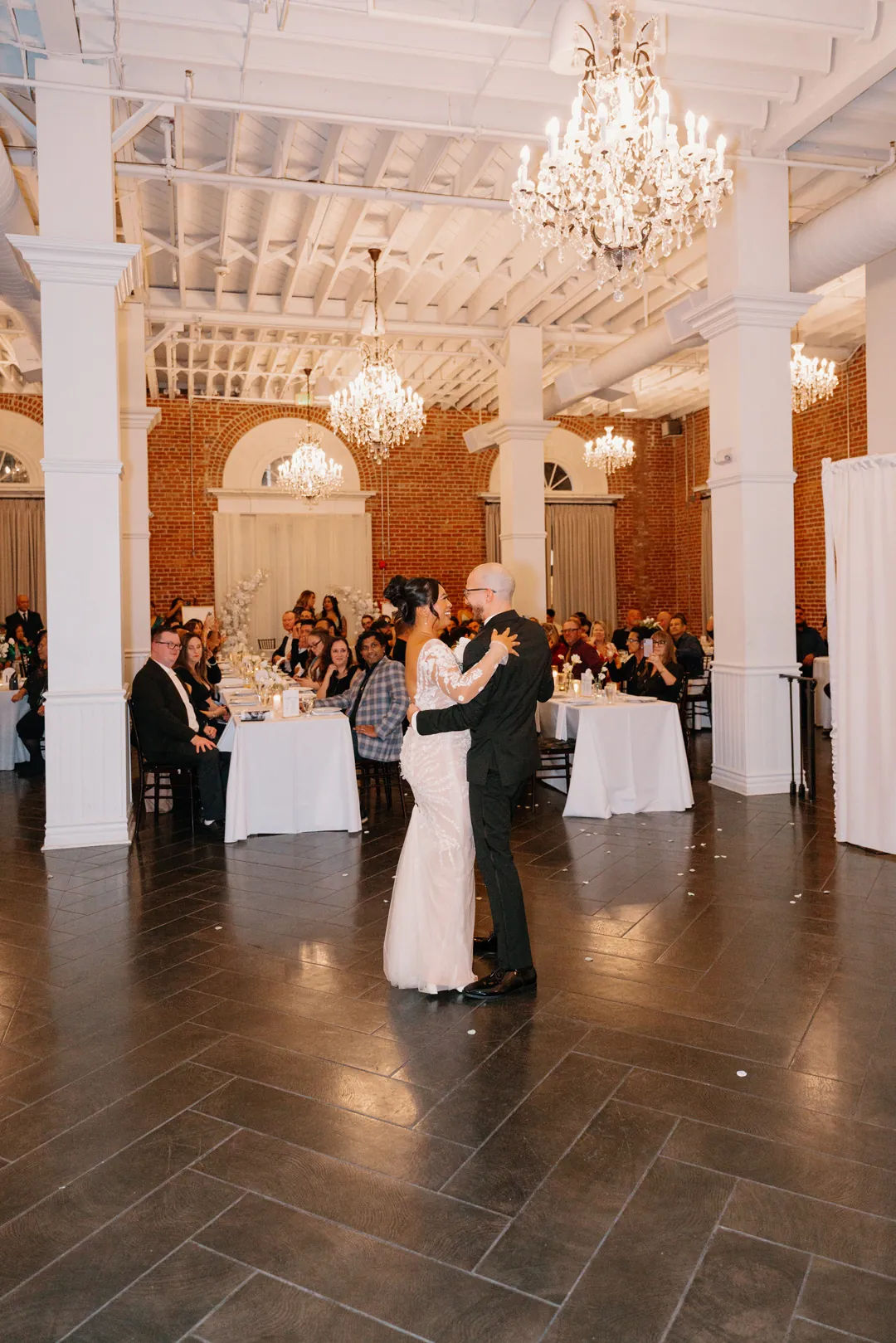 Couple dancing together beneath a chandelier