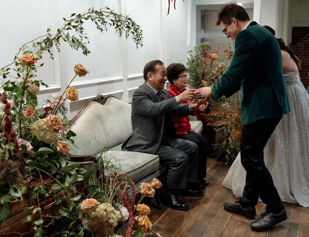 Couple serving tea to seated guests during a ceremony