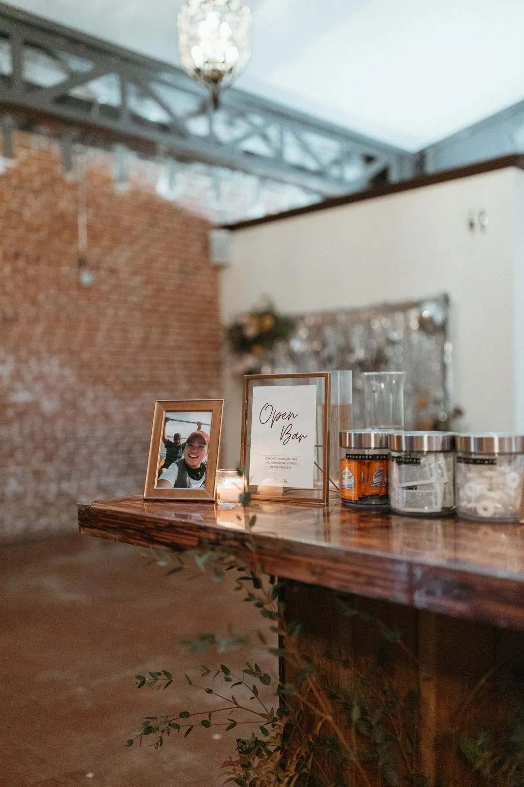 Drinks display on a wooden bar beside a brick wall