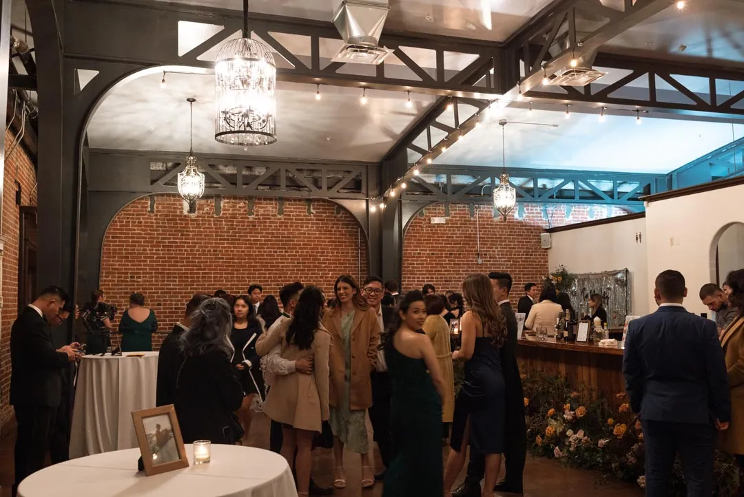 Guests gathered beneath chandeliers in a cocktail reception room