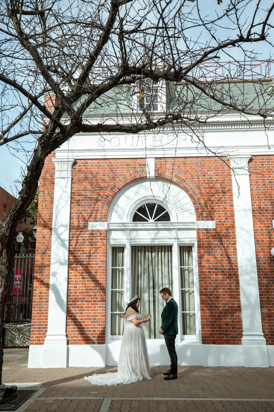 Couple standing together in front of a brick building