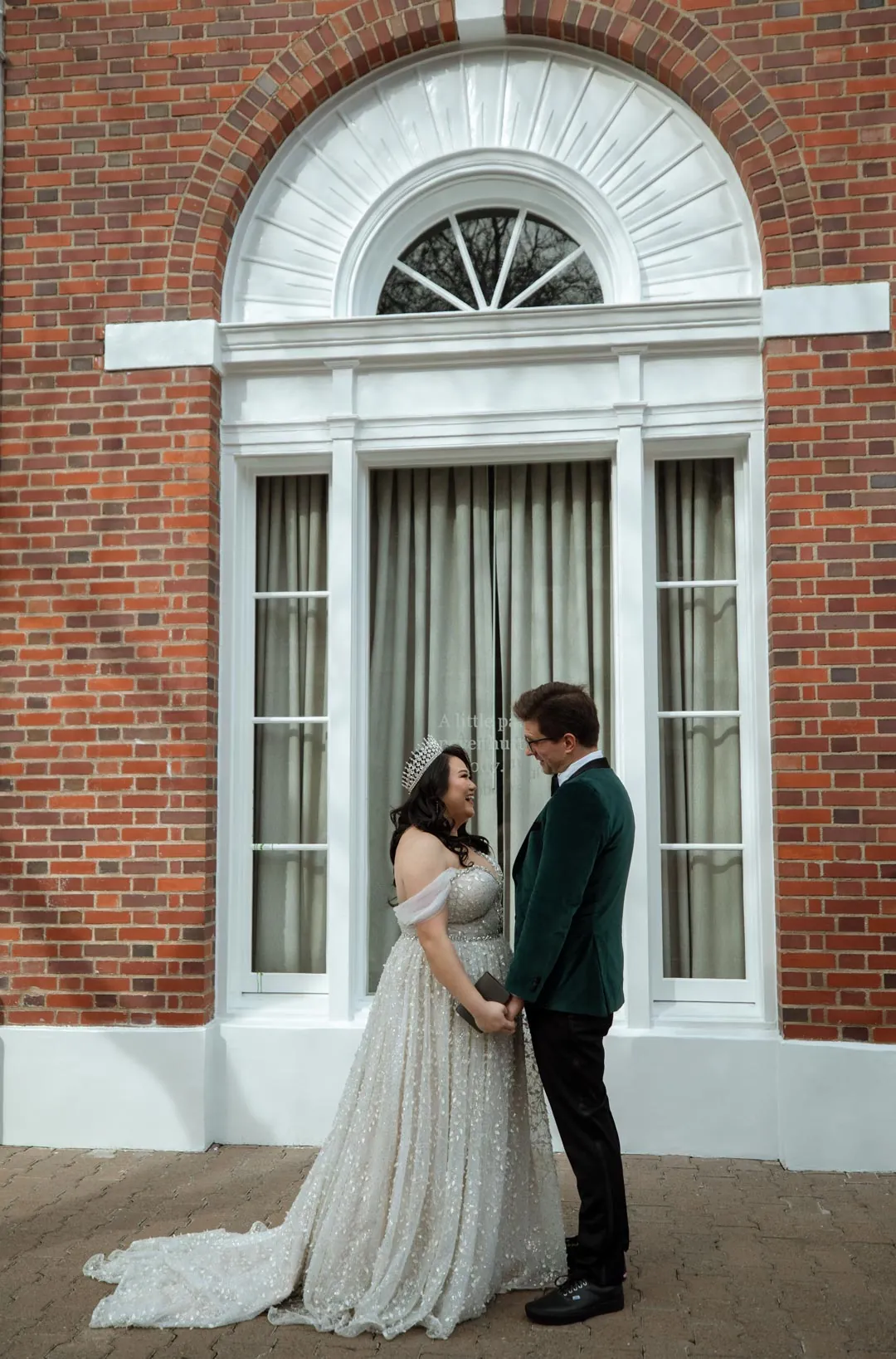 Couple standing face to face outside a brick building