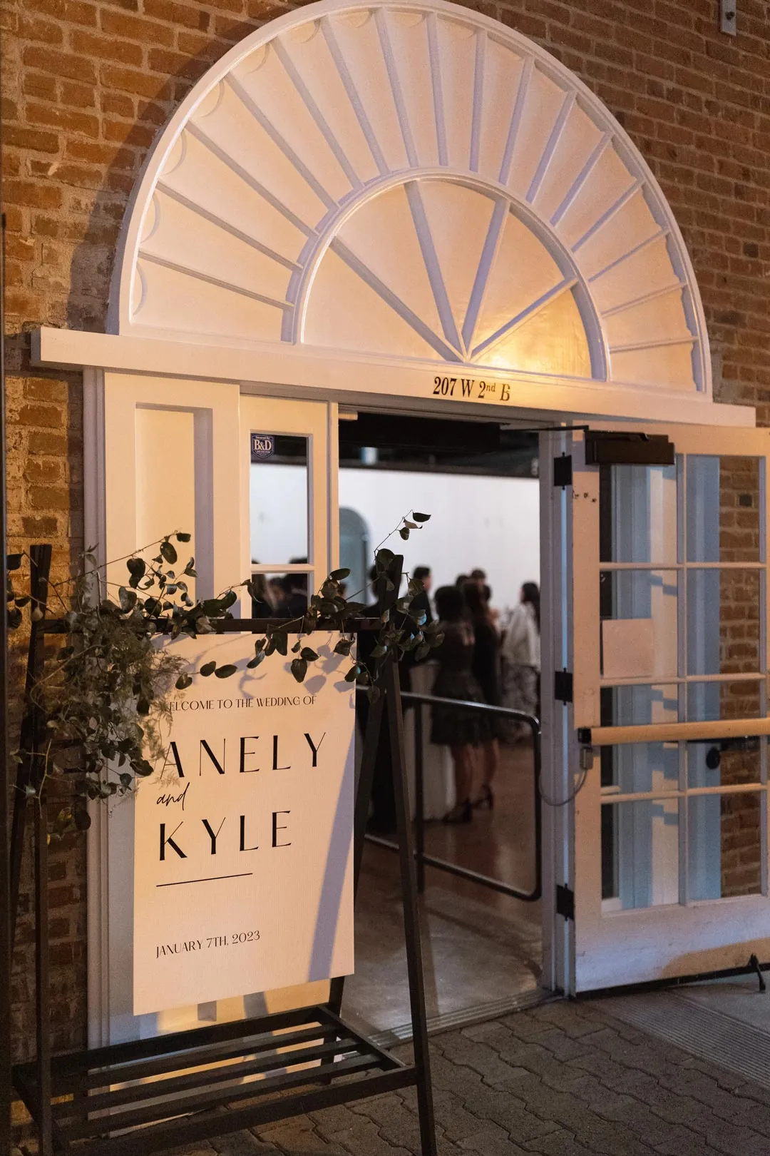Wedding welcome sign beside an open arched doorway