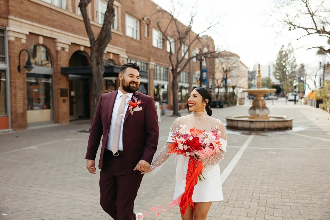 Couple walk along a brick paved downtown street.
