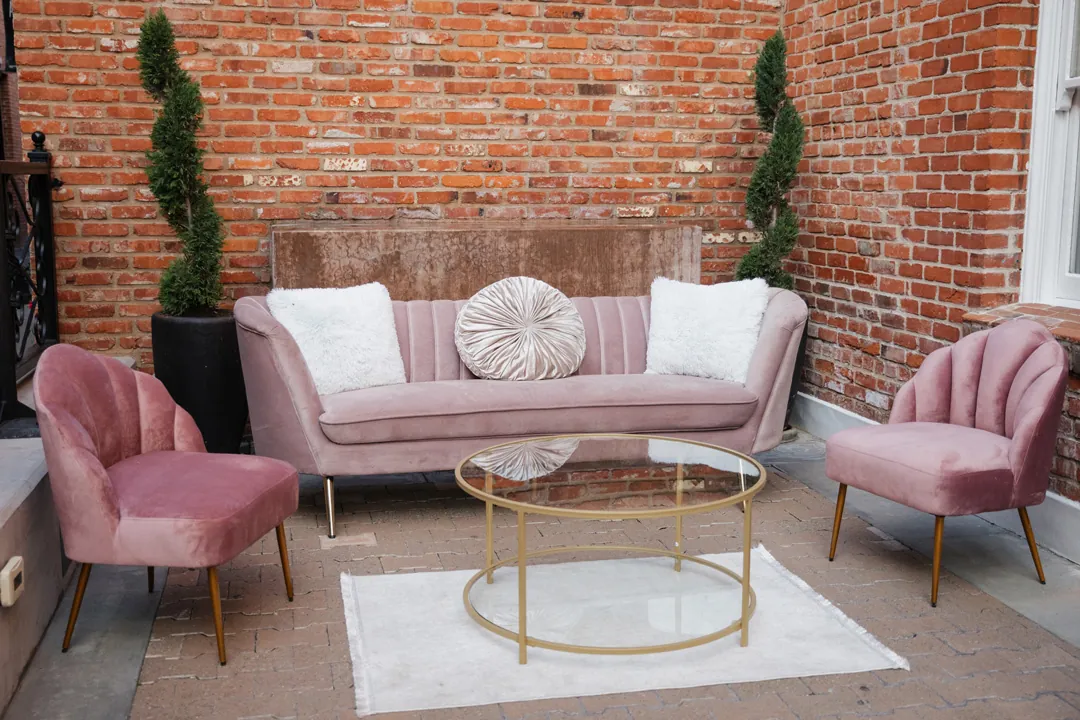 Pink lounge seating surrounds a round glass table.