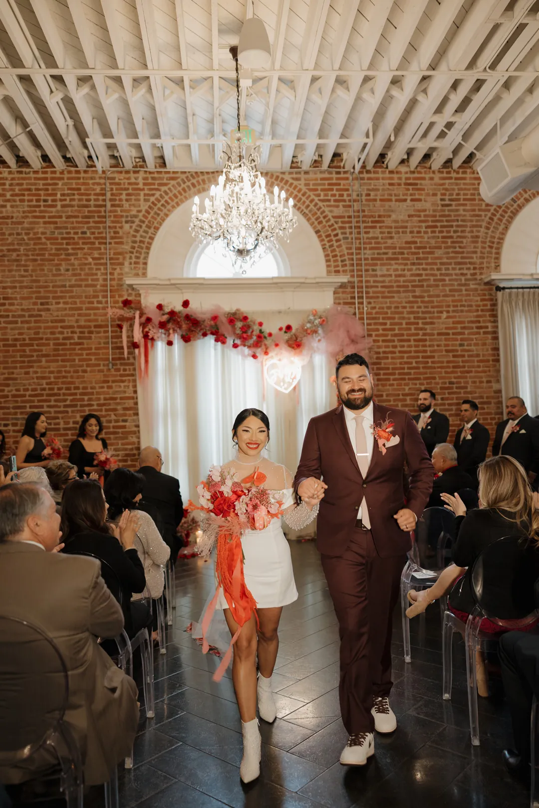 Newlyweds walk down the aisle as guests watch.