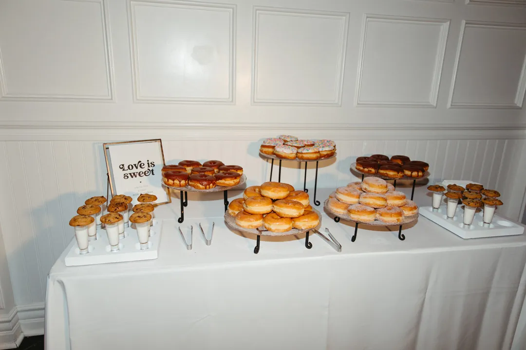 Pastries arranged on stands on a white dessert table.