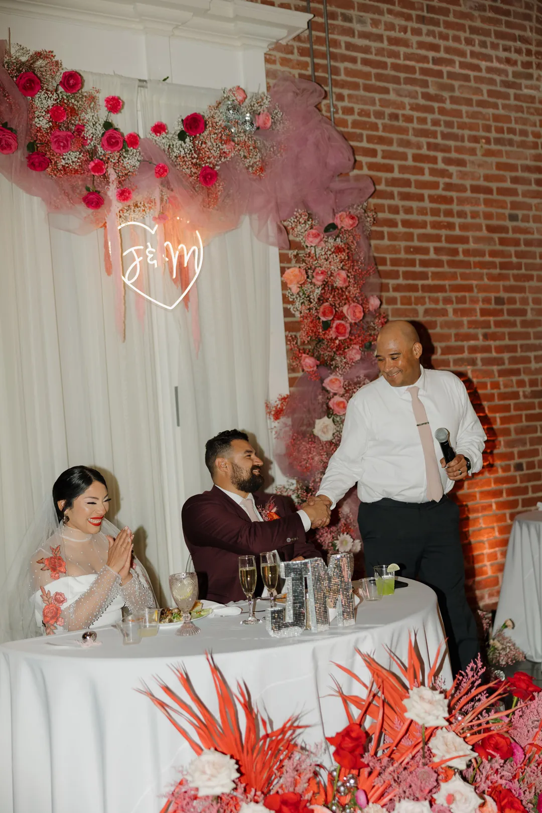 Guest speaks at the floral sweetheart table.