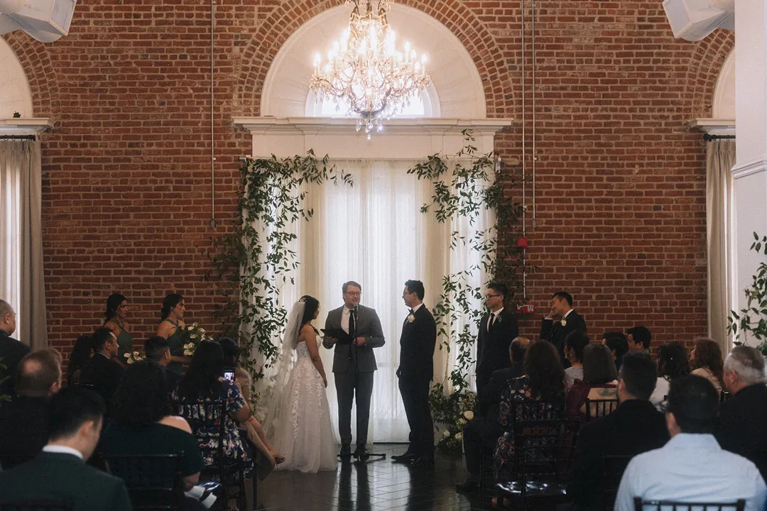 Couple exchanging vows before their wedding guests
