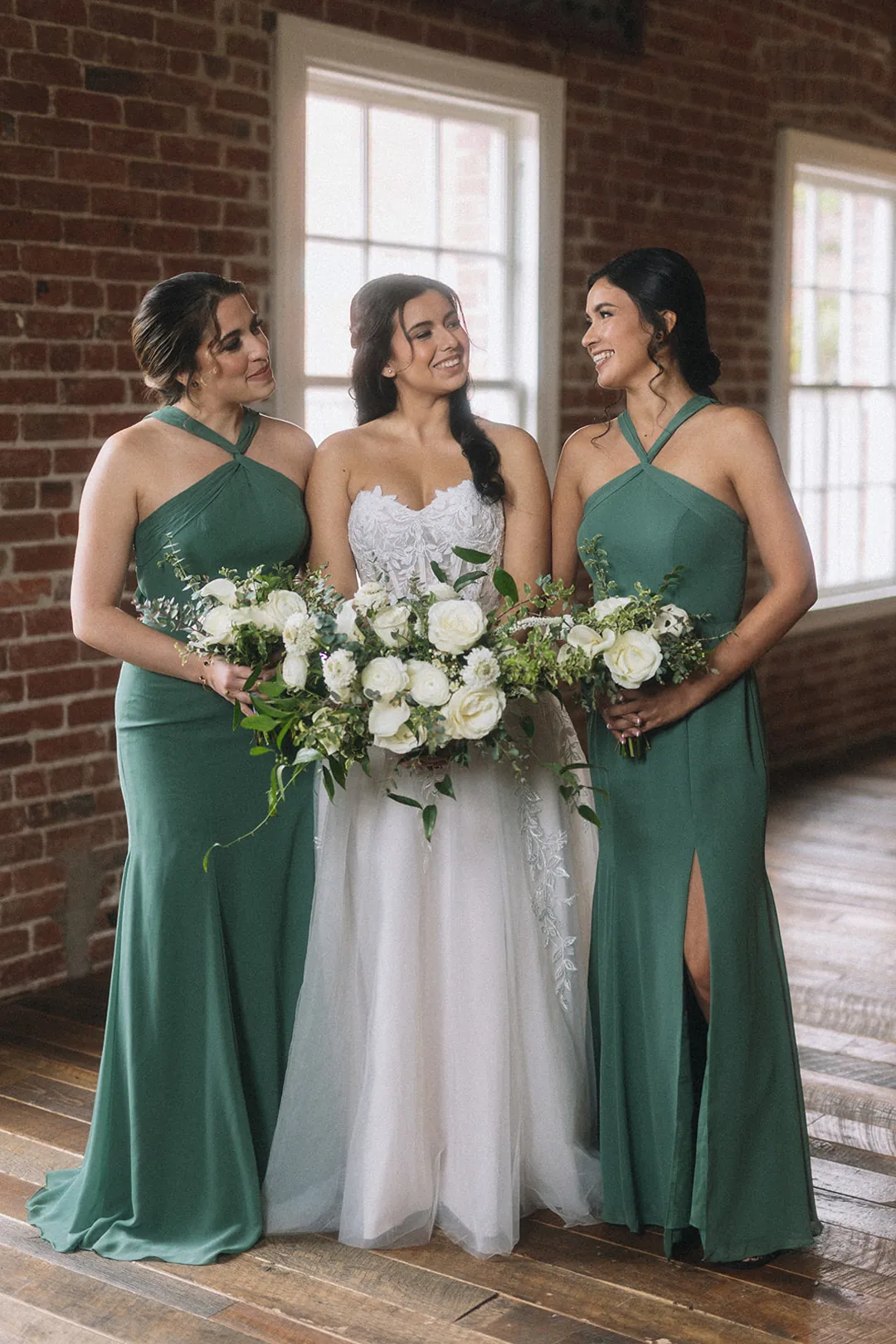 Bride posing with attendants in green dresses