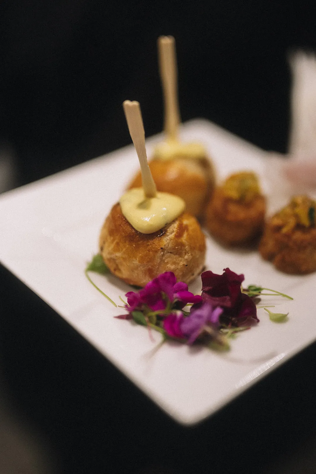 Plated bite-size appetizers with a floral garnish