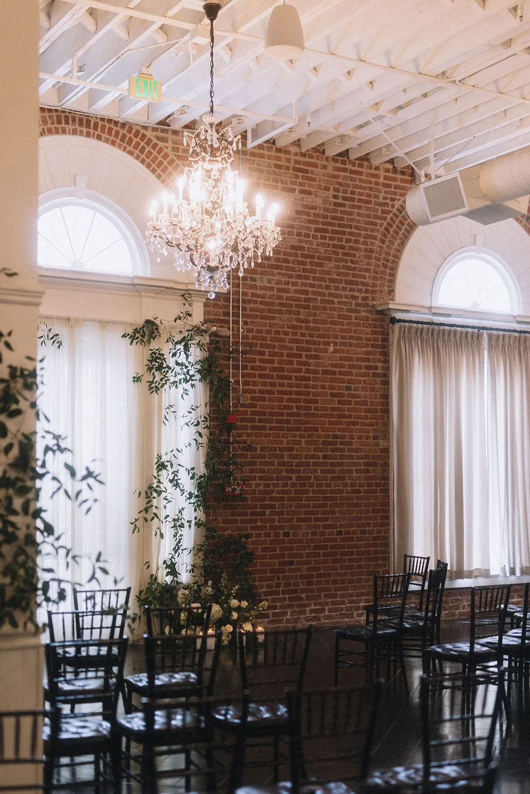 Ceremony seating beside tall ballroom windows