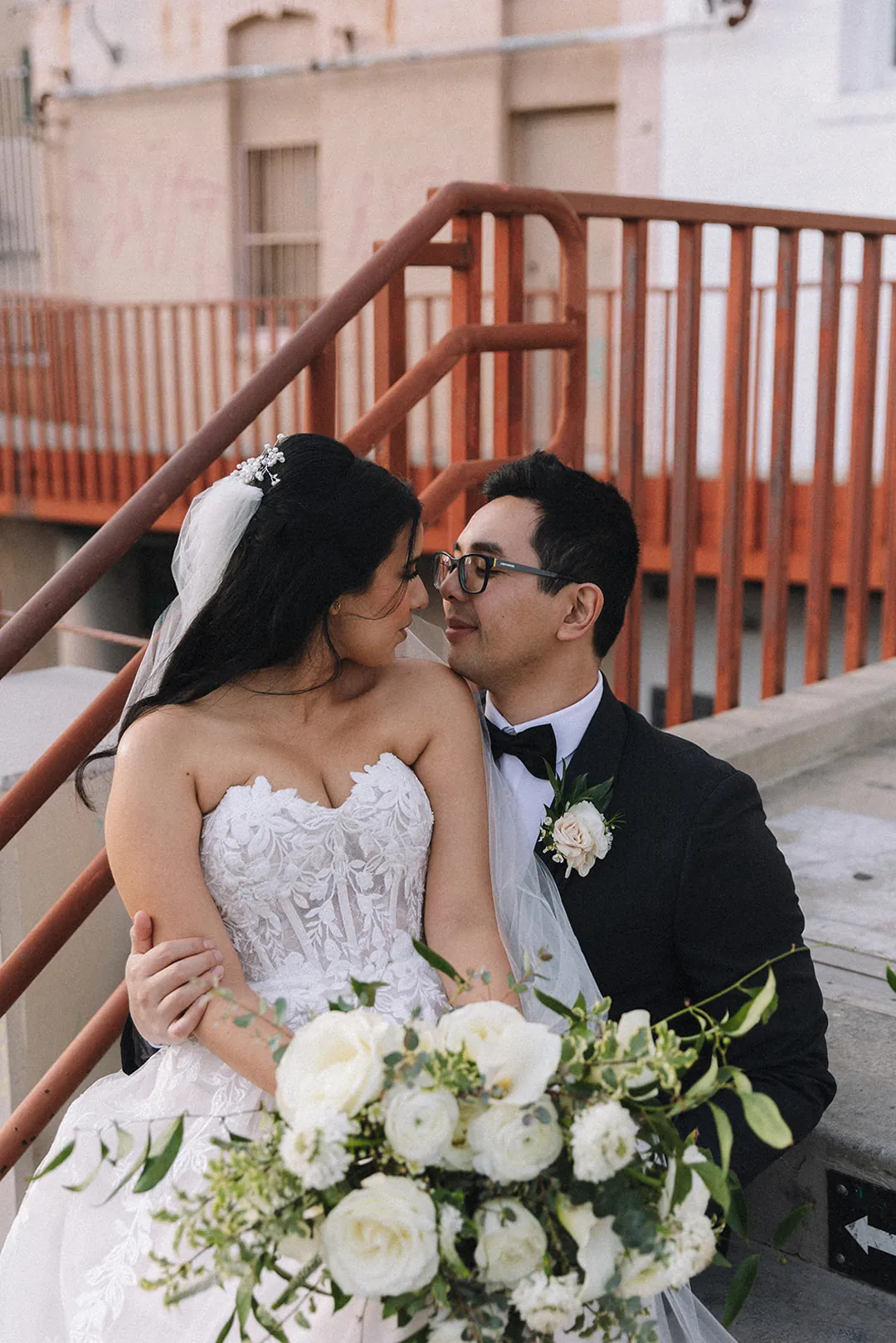 Bride and groom kissing beside the venue staircase