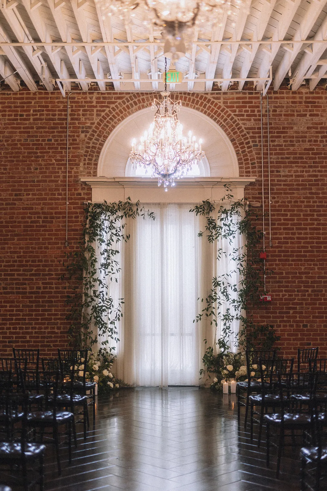 Ceremony chairs beneath a greenery-decorated arch