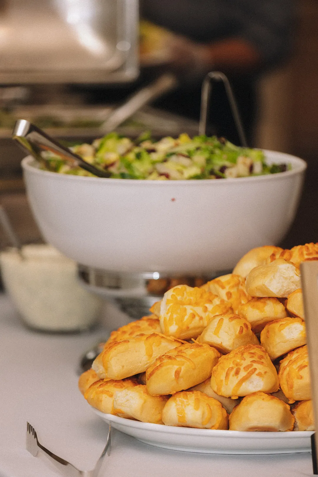 Salad bowl and bread rolls at a buffet