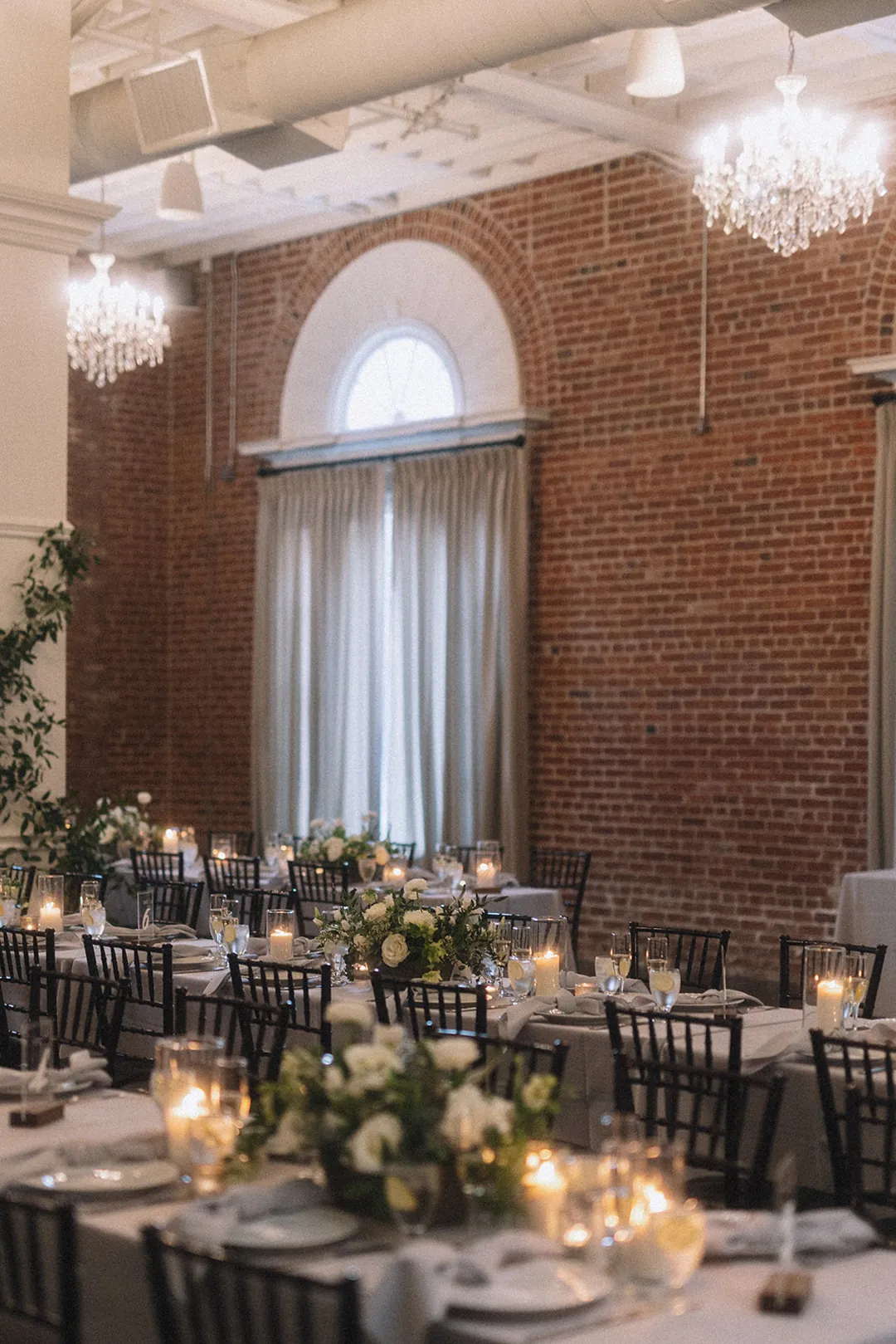 Reception tables beside the ballroom's tall windows