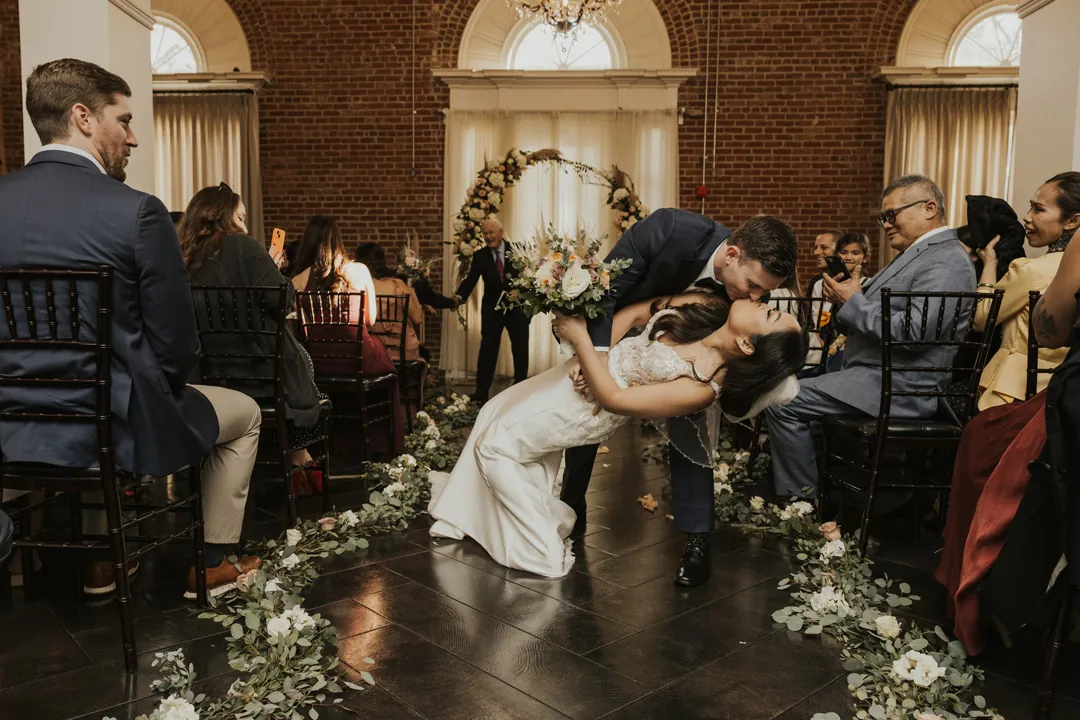 Groom dips the bride at the end of the ceremony aisle.