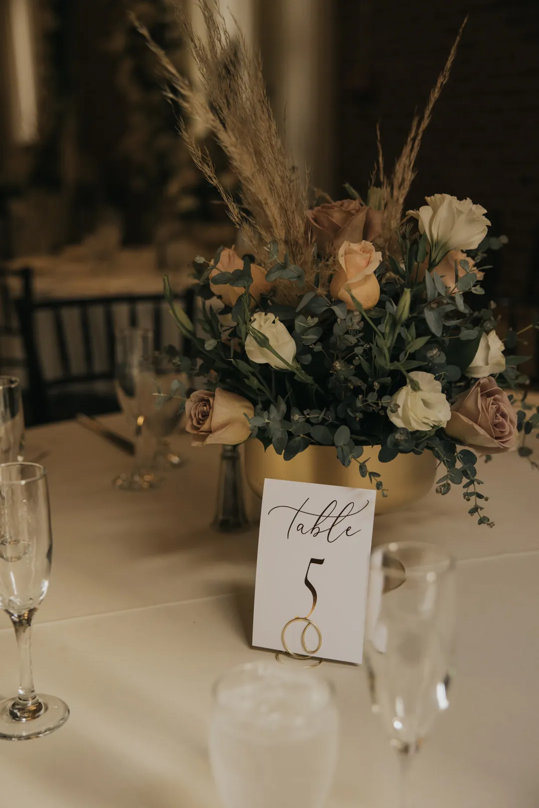 Table number five beside a floral centerpiece.