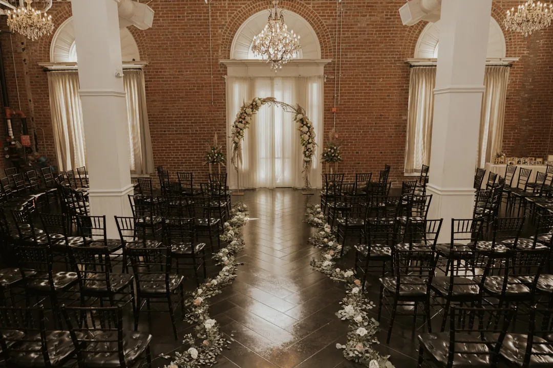 Empty ballroom aisle with flowers and candles.