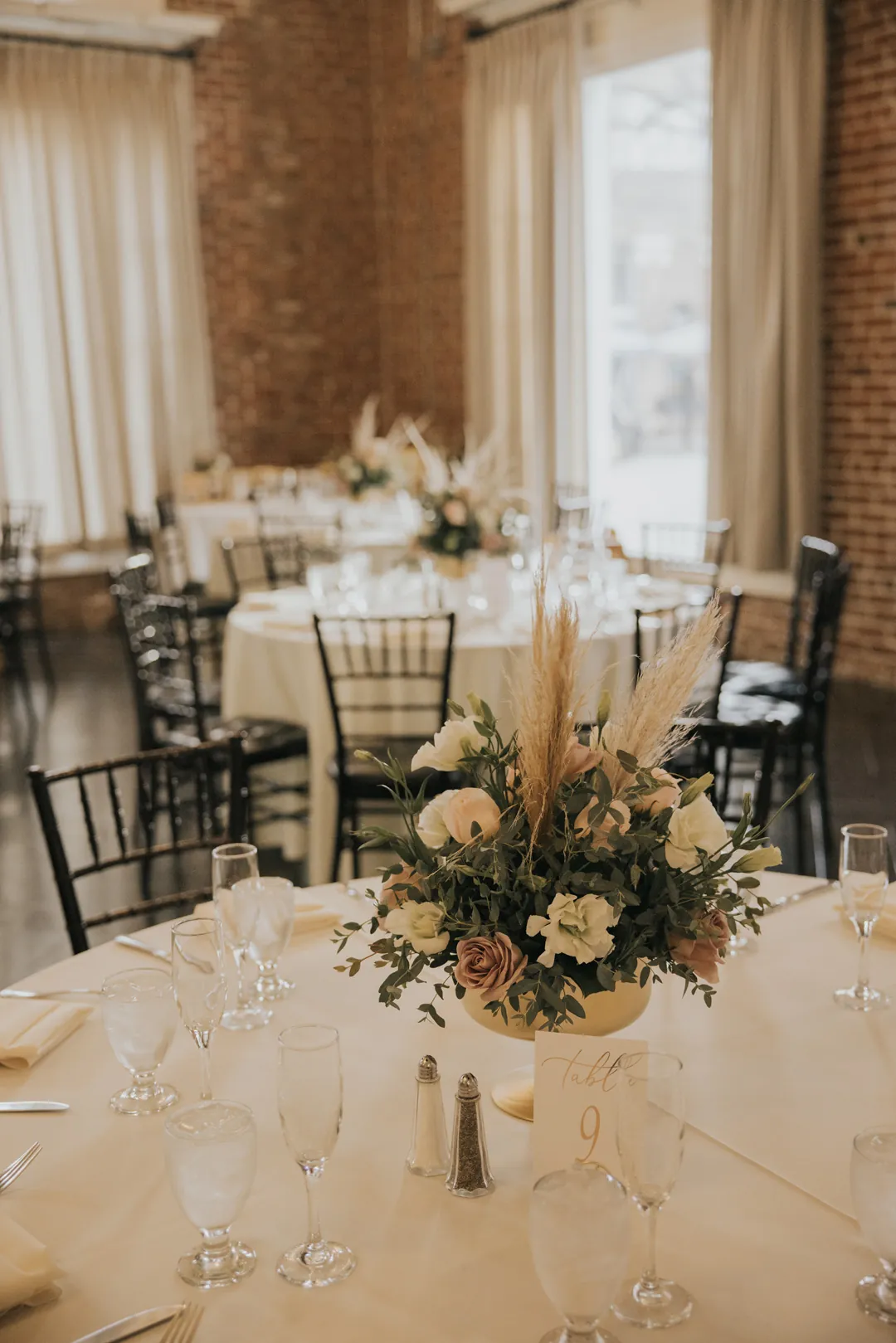 Reception tables decorated with flowers and white linens.