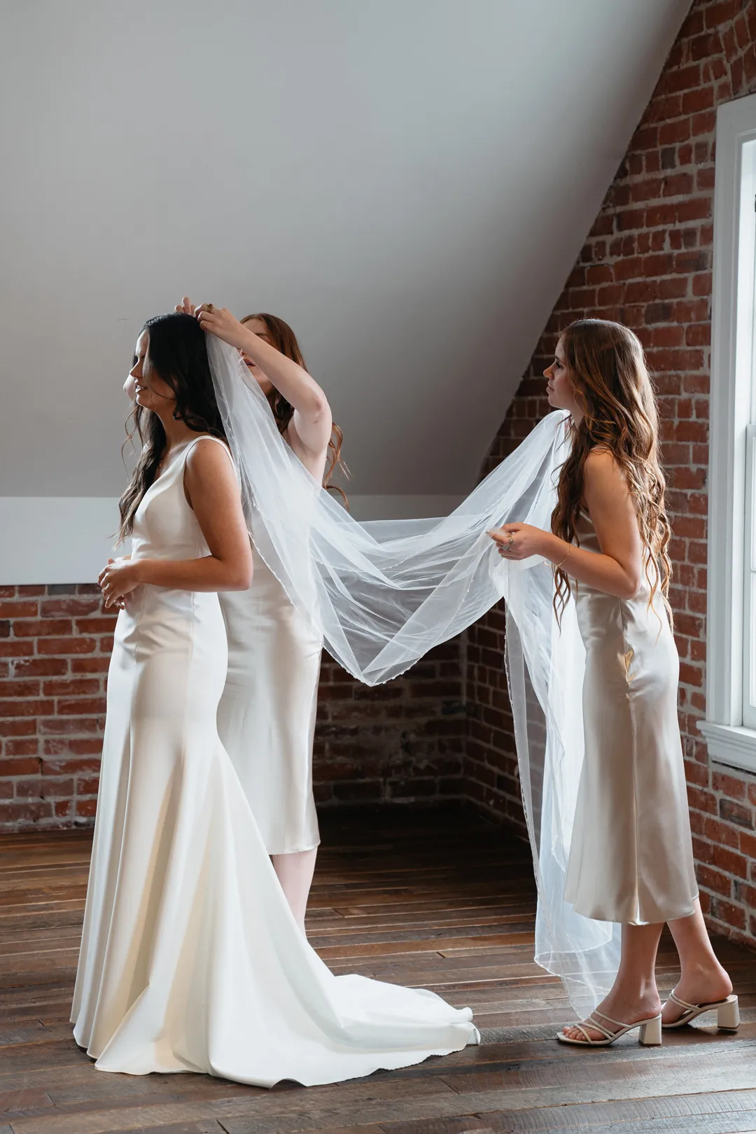 Attendants adjusting the bride's veil