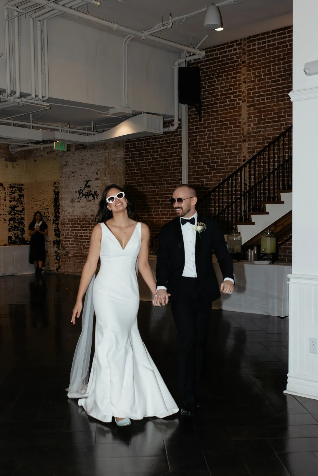 Couple entering their reception beside the staircase