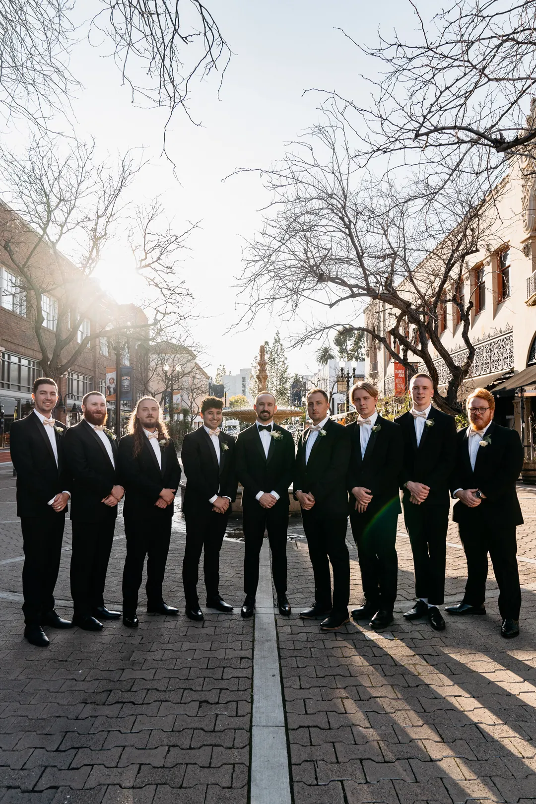 Groom and groomsmen standing in a line on a city street