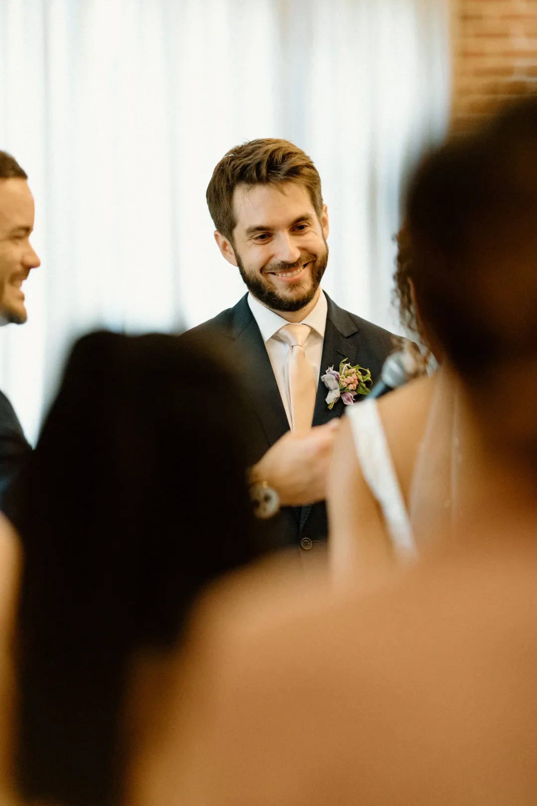 Groom smiling toward the bride during the ceremony