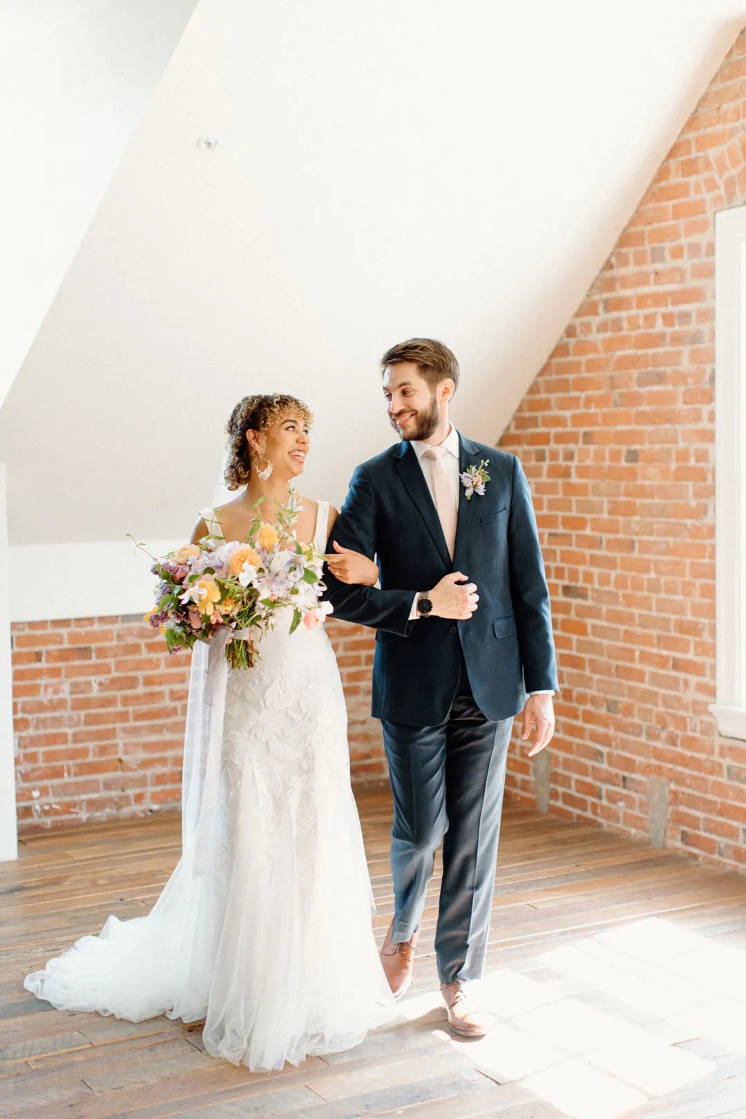 Couple posing together beneath a sloped ceiling