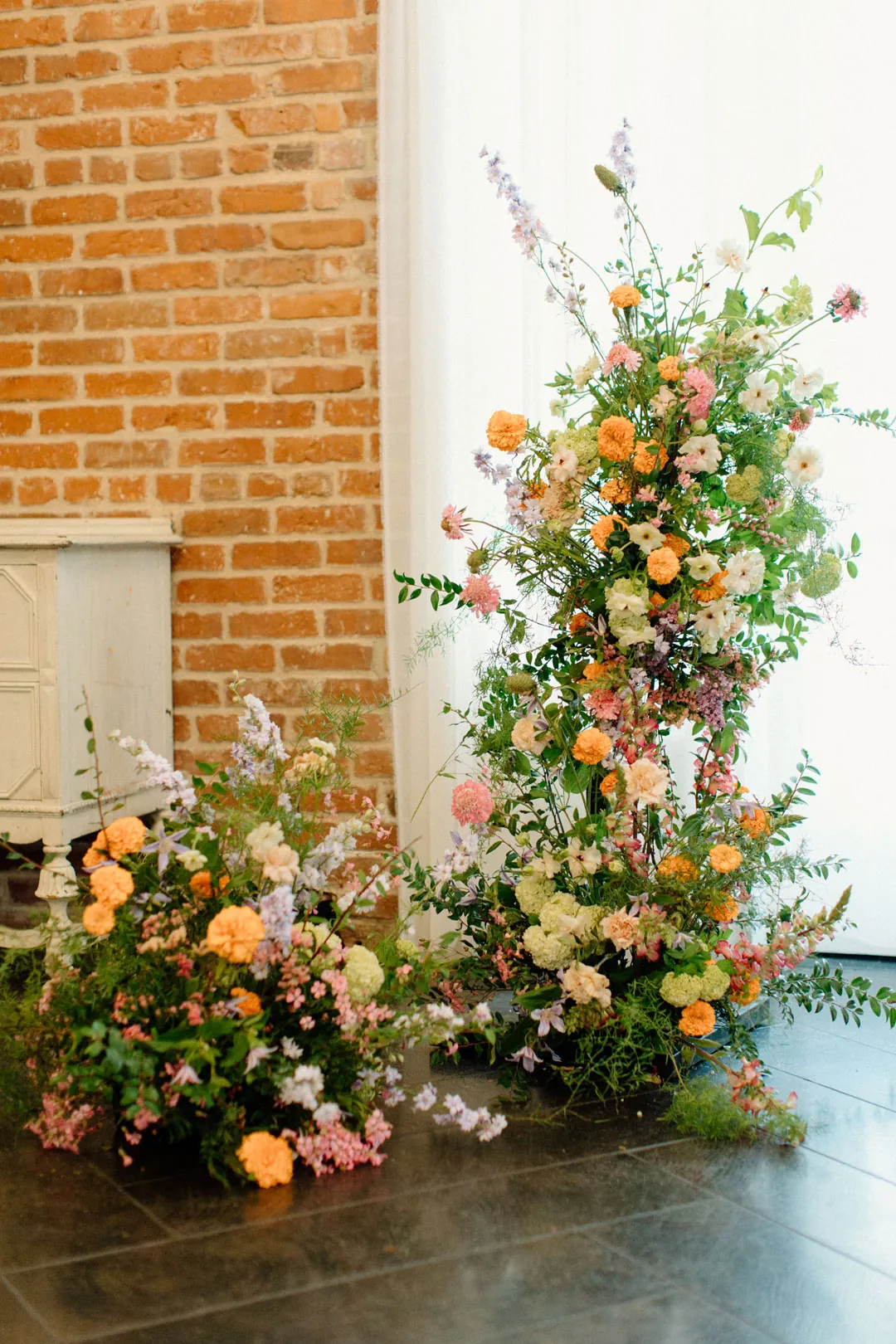 Colorful flowers and greenery on a tall ceremony arrangement