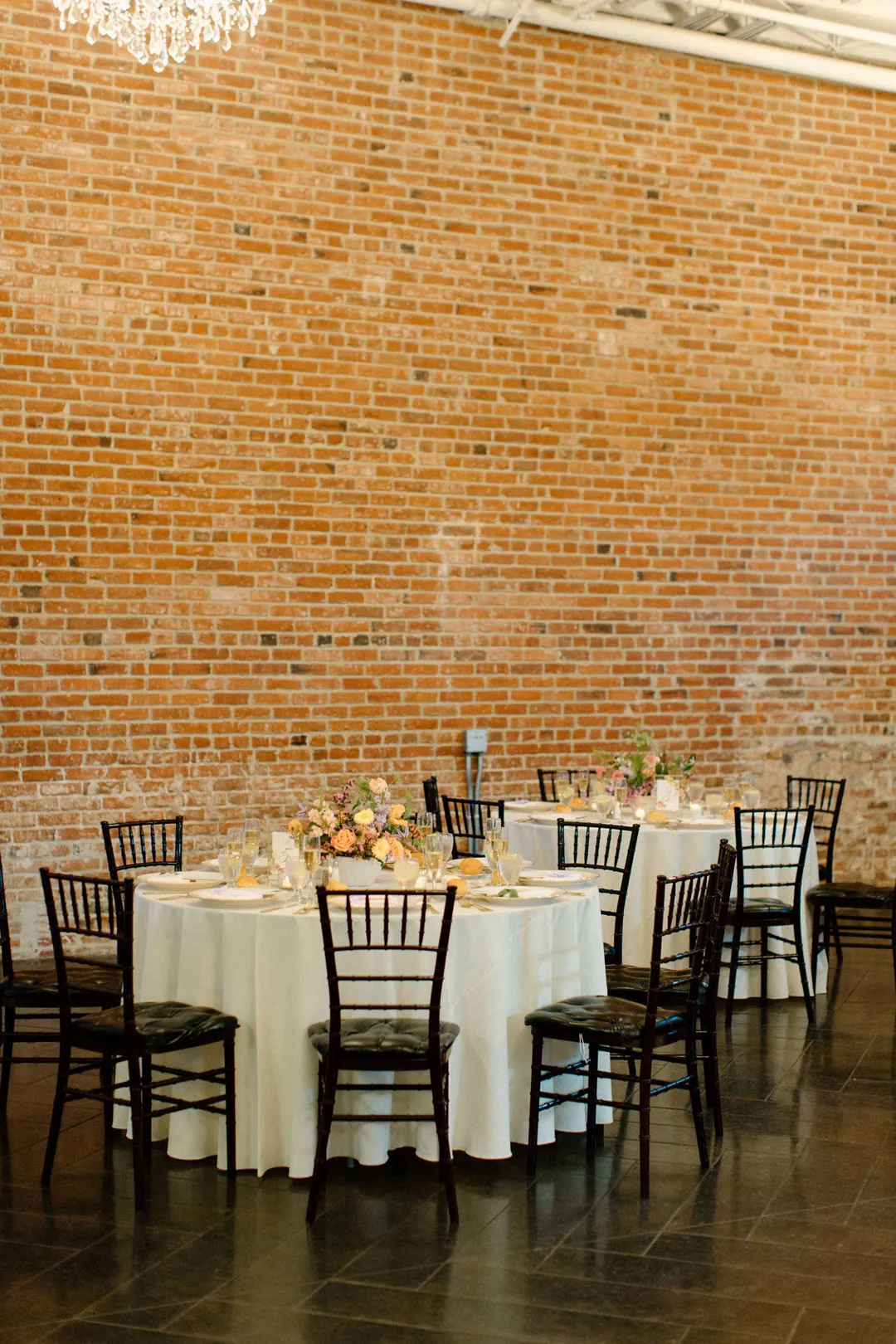 Small dining table set beside an exposed brick wall