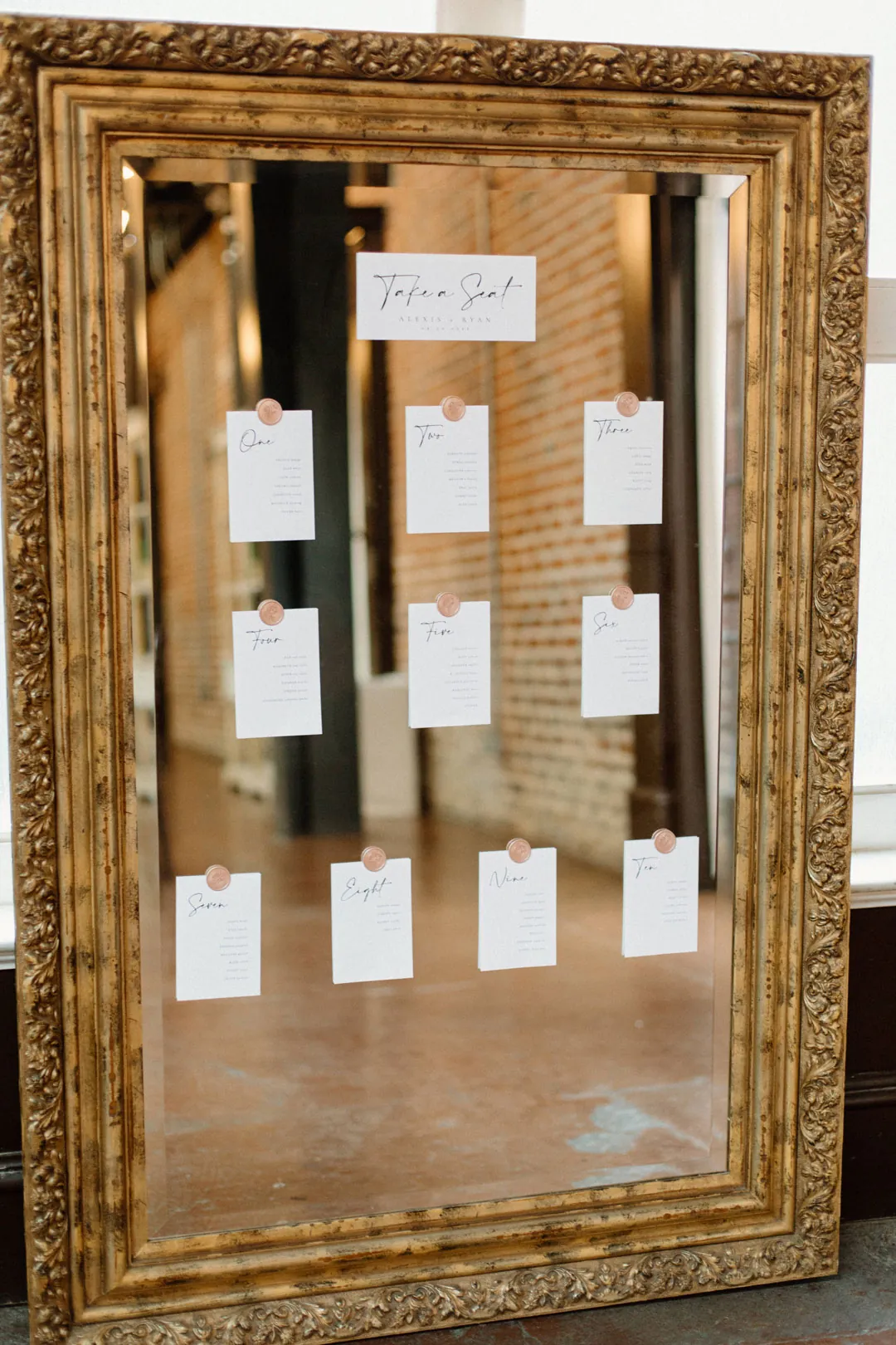 Seating cards displayed inside a large gold frame
