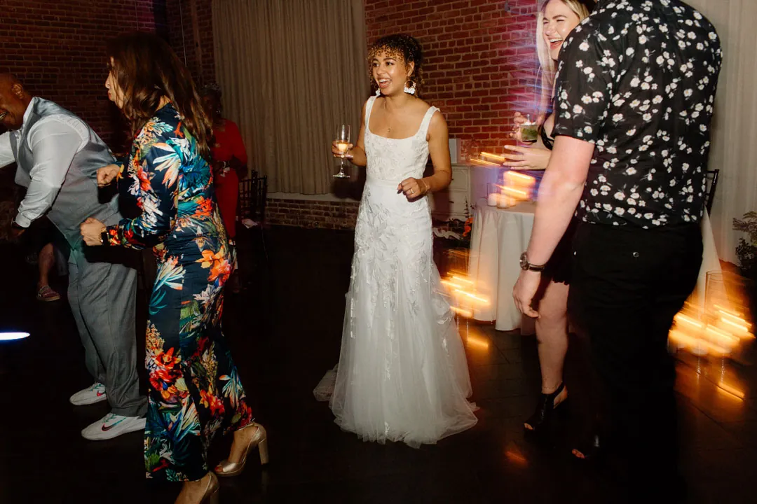 Bride dancing among guests in the reception room