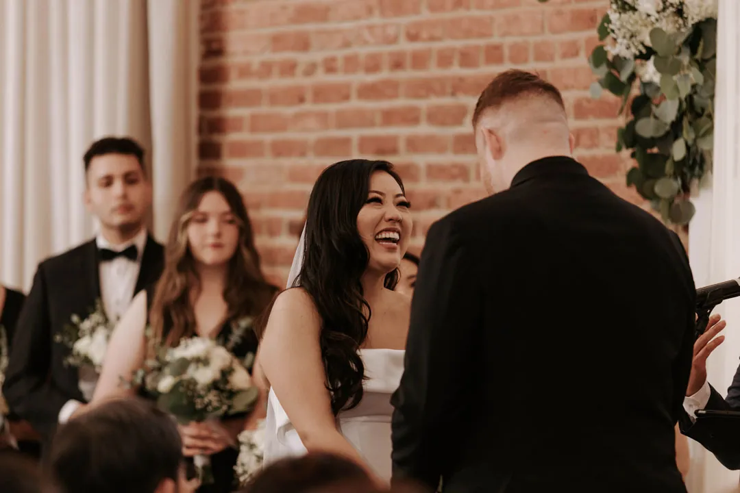 Bride smiles at the groom during their ceremony.