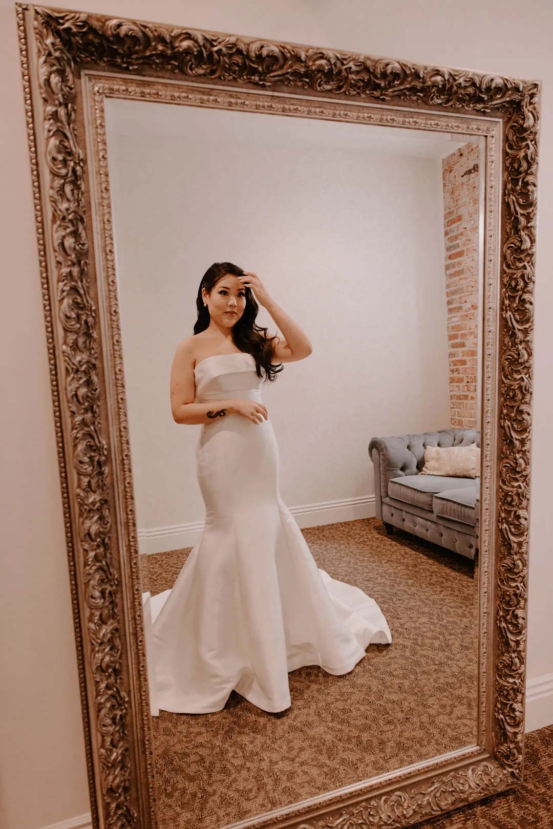 Bride's reflection in an ornate full length mirror.
