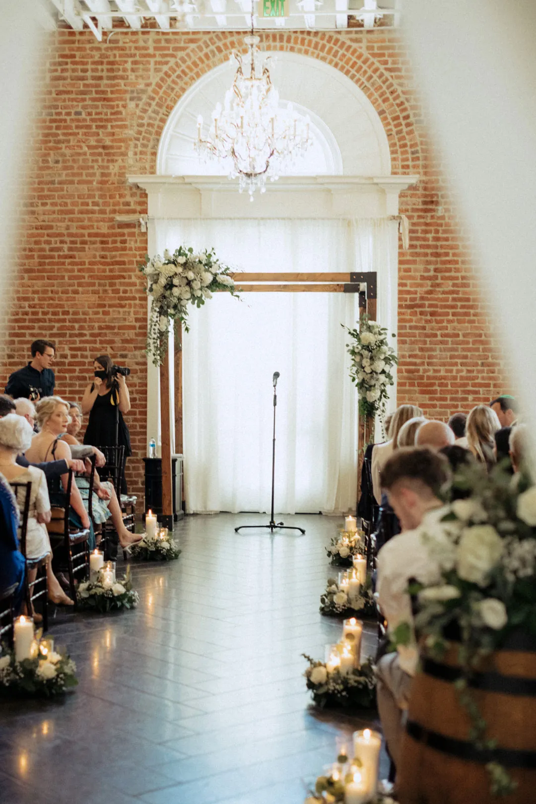 Wedding ceremony aisle beneath a large arched window