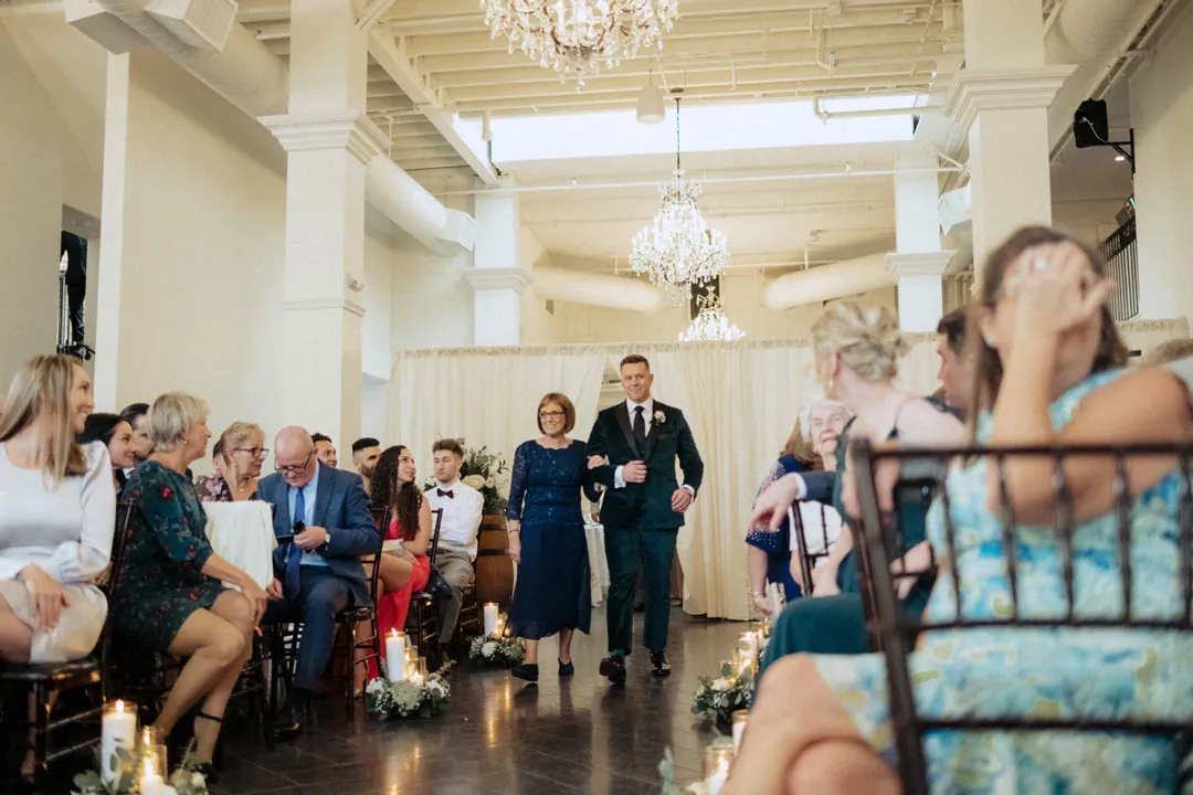 Guests seated along the aisle as the wedding party enters
