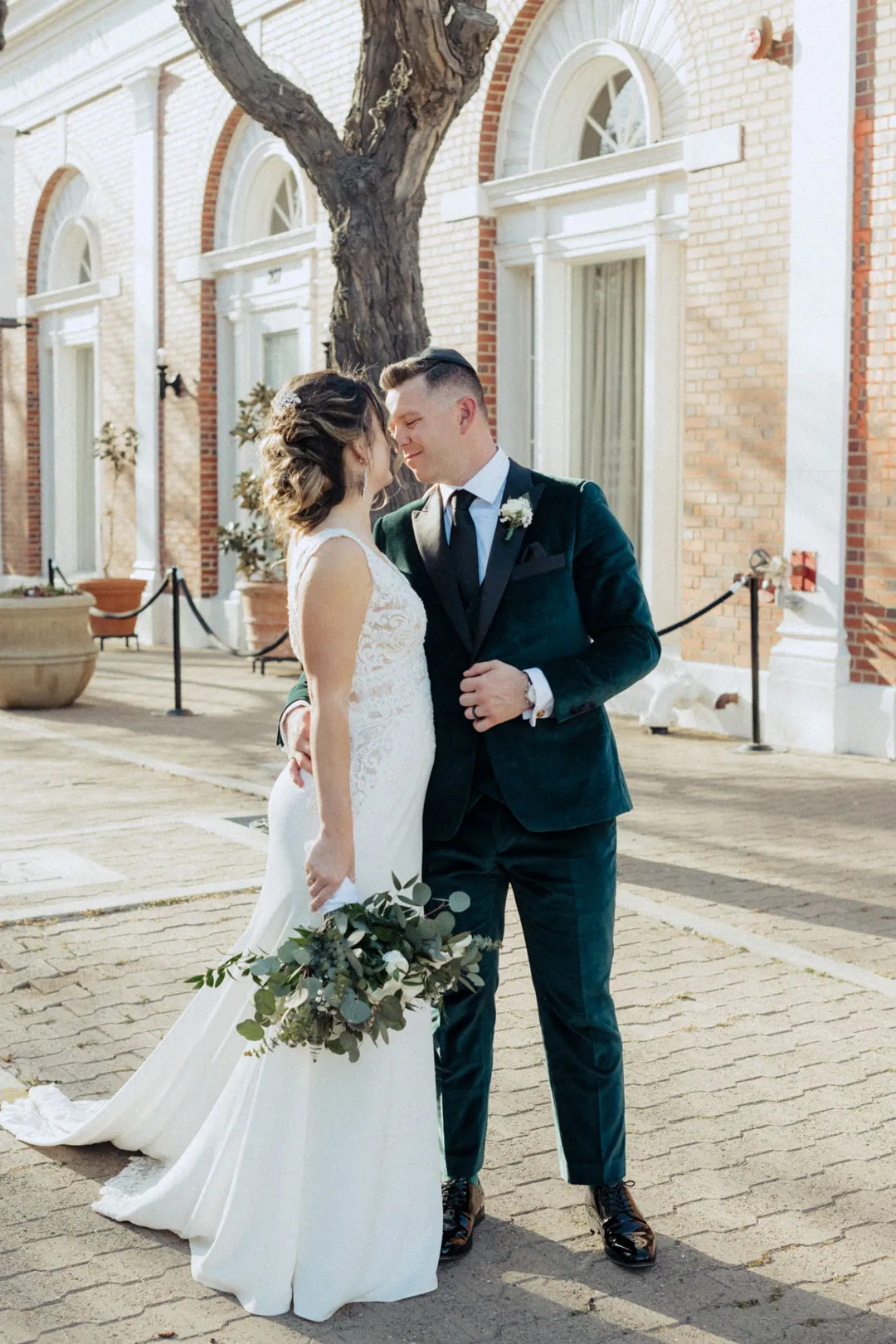 Couple kissing outside a brick building