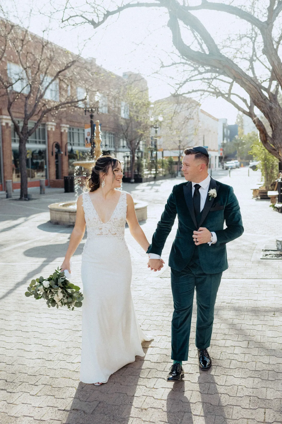 Couple walking hand in hand across a city street
