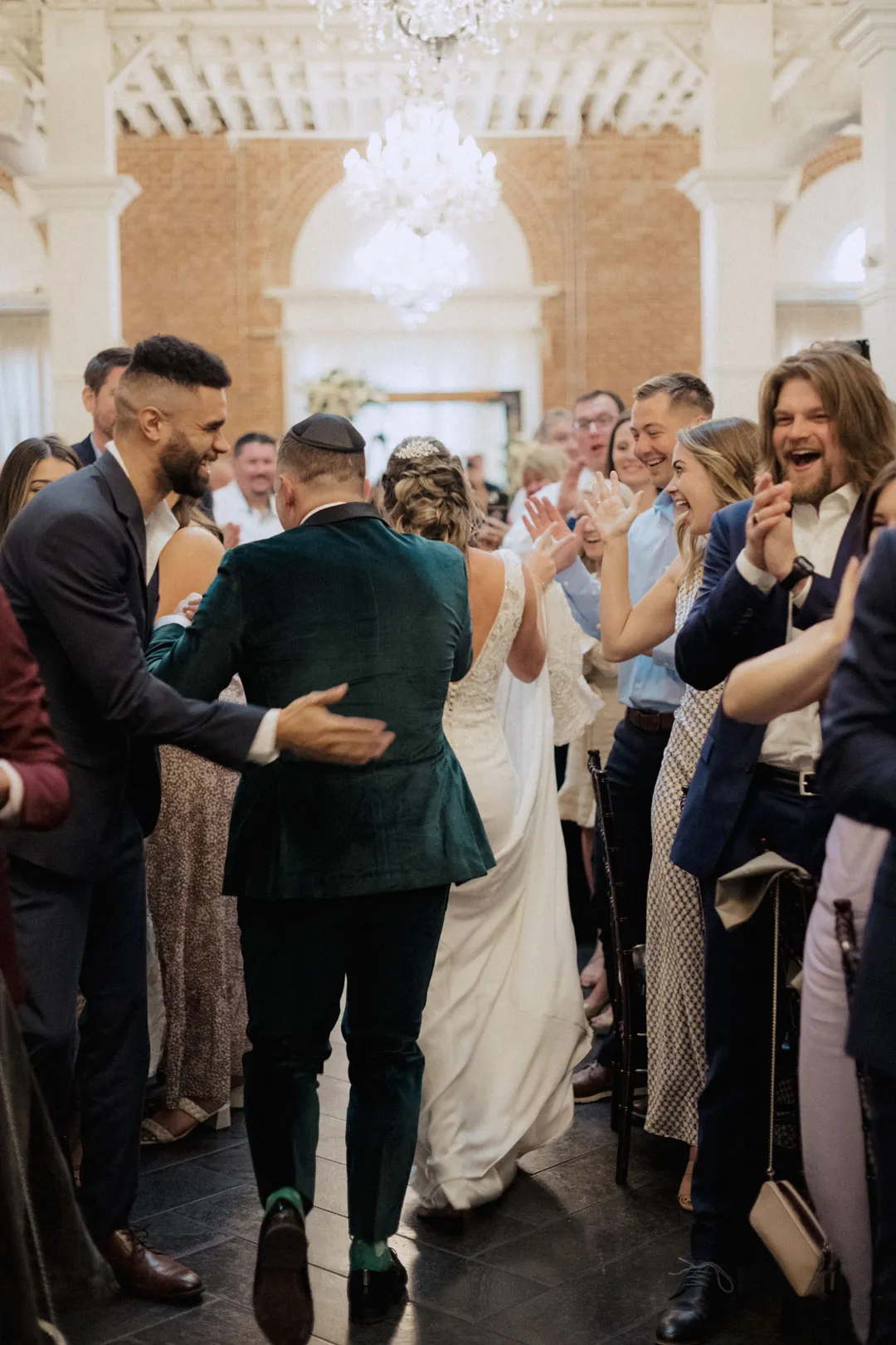 Newlyweds welcomed by applauding reception guests