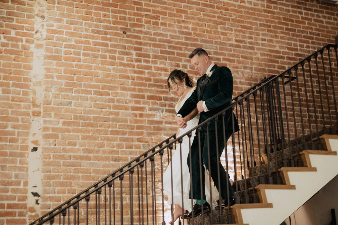 Couple descending a staircase with an iron railing
