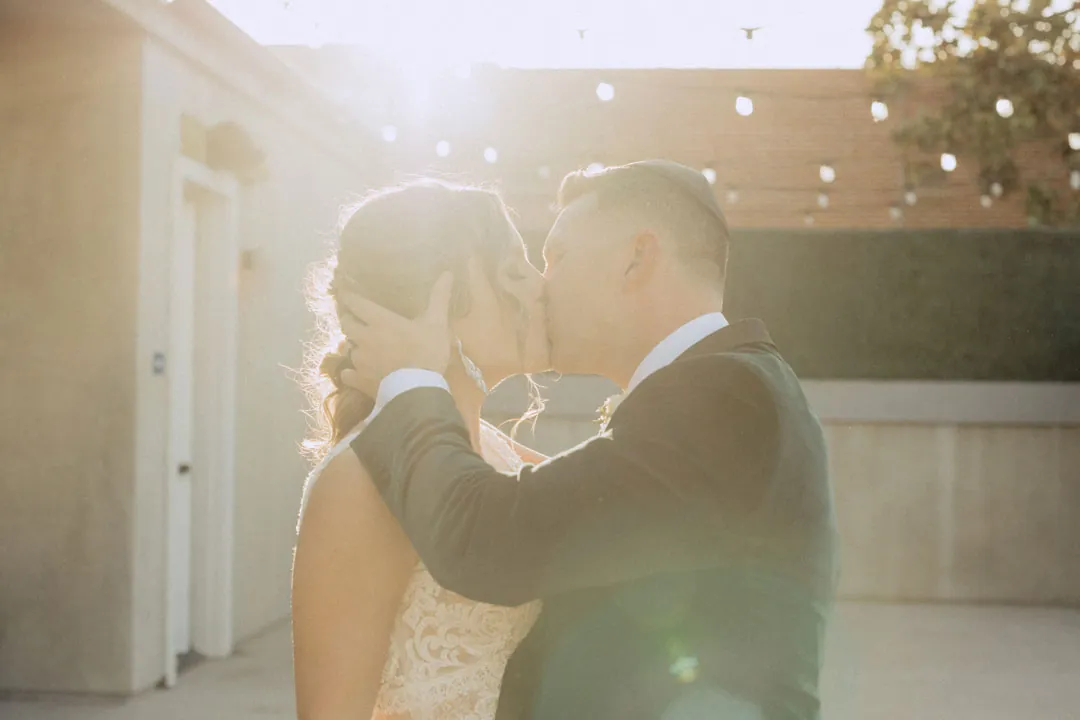 Couple embracing in sunlight on an outdoor terrace