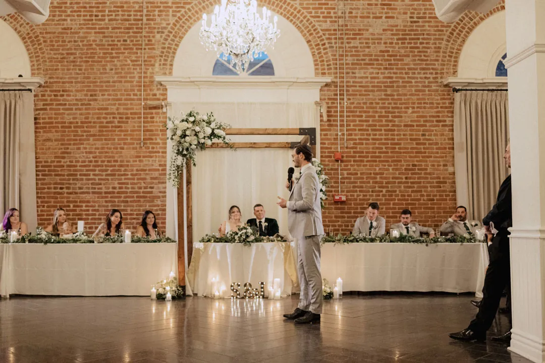 Speaker standing before the couple's candlelit table